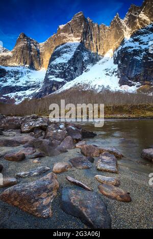 Early morning sunlight on the peaks Trolltindene and Trollveggen, or the Troll Wall, in Romsdalen valley, Rauma kommune, Møre og Romsdal, Norway. Stock Photo