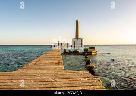 Sanganeb Reef Lighthouse near Port Sudan, on the Red Sea, in Sanganeb National Park, wooden pier view with a lighthouse in the distance, golden hour, Stock Photo