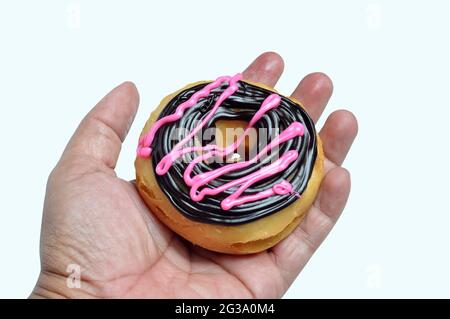 Donuts with chocolate and strawberry cream on hand Stock Photo