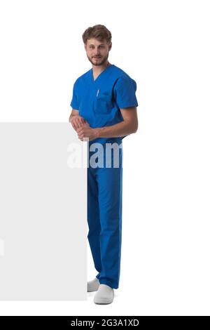 Full length portrait of a handsome caucasian male doctor nurse with blank banner isolated on white background Stock Photo