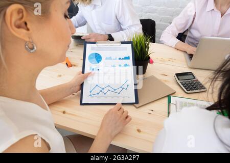 Diverse executive business people team discussing work results at meeting, multiracial businessmen talking analyzing financial statistics report sitti Stock Photo