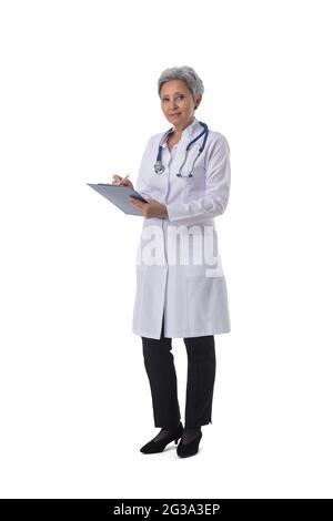 Mature female asian doctor woman taking notes full length portrait isolated on white background Stock Photo