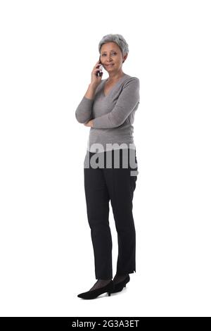 Beautiful mature Asian woman business talking on mobile phone Stock Photo