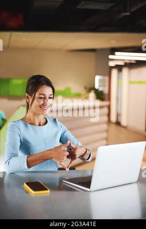 Beautiful elegant Caucasian woman personal consultant having interesting online discussion with partner in office space Stock Photo
