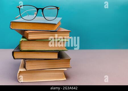 Stack of books with reading glasses on top Stock Photo