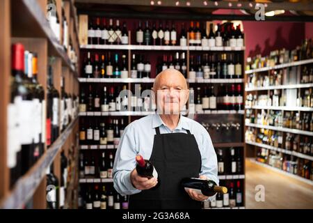 vintner offering wine in modern wineshop Stock Photo