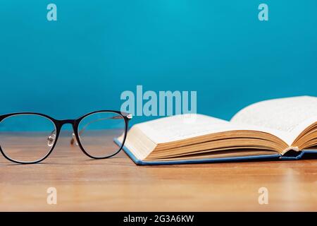 Close-up of reading glasses and opened book Stock Photo