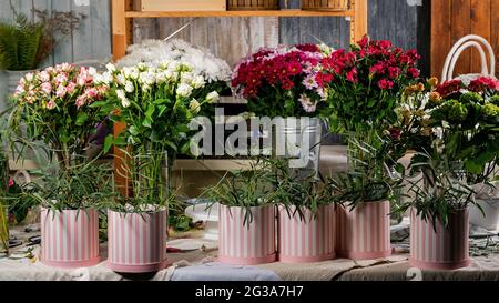 Florist table workplace. Flower hat boxes, various flowers, greenery accessories on the desktop. Workspace. Small business concept. Flowers and access Stock Photo