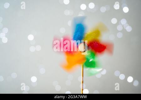 Colorful turning pinwheel on shiny white background. Summer fun Stock Photo