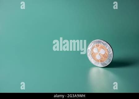 Ripple XRP crypto single coin on green background with copy space. Web banner with popular cryptocurrency Stock Photo