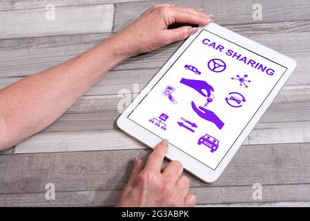Car sharing concept shown on a tablet used by a woman Stock Photo