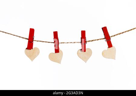 Small wooden hearts with red clothes pegs on a rope isolated on white background Stock Photo