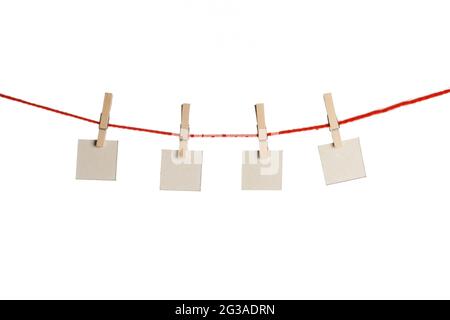 Set of four white blank paper notes held on red string with clothespins isolated on white background Stock Photo