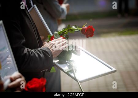 Red rose and diploma in hands during the awarding ceremony Stock Photo