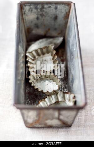 Old vintage baking tin and baking moulds on white background. Selective focus. Stock Photo