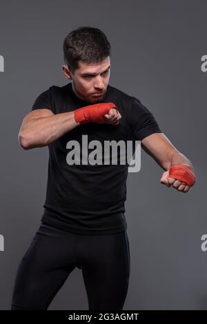 Sportsman with boxing bandages on hands working out defensive techniques Stock Photo