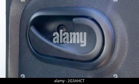 The car is inside. Closeup of car door handle, car door inside. Inner plastic car door handle Stock Photo
