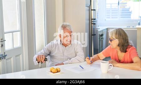 Retired senior couple solving puzzles as brain teasers and memory training at home Stock Photo