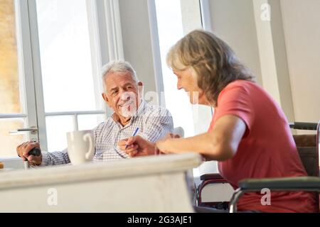 Retired senior couple solving puzzles together as memory training and brain jogging Stock Photo