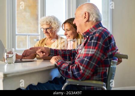 Senior couple and young woman having fun together streaming video on laptop computer Stock Photo