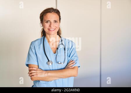 Confident woman as a doctor or nurse with stethoscope with crossed arms Stock Photo