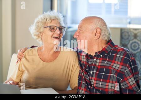Happy retired couple hugging each other full of love at home or retirement home Stock Photo