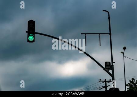 traffic light burning green on the dark clouds background. traveling indoors on a rainy day Stock Photo