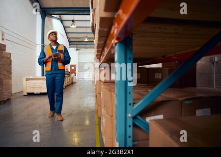 Portrait of african engineer inspector checking the stock in the warehouse using digital tablet Stock Photo
