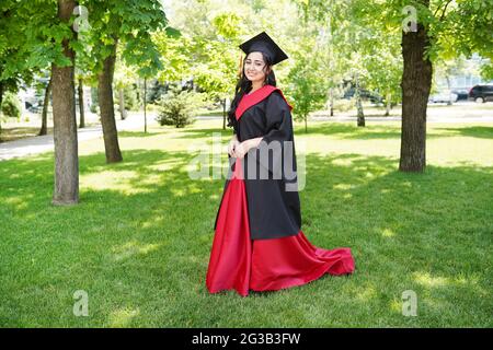 successful happy graduating student with nature green background near university. Stock Photo