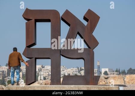 Israeli visitor exploring the famous AHAVA (love in Hebrew), Cor-ten steel 12-foot high sculpture by Robert Indiana at Israel Museum. Jerusalem