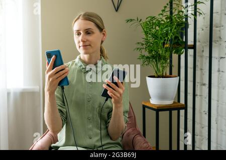 woman transfer data from old to new phone with cable connection Stock Photo