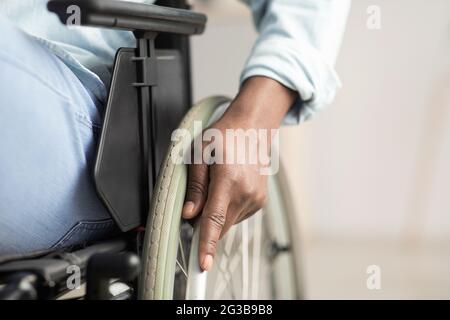 Man controlling equipment, health care in clinic and support of invalid human. Middle aged african american male disabled in wheelchair. Selective foc Stock Photo
