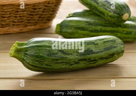 Single fresh raw green spotted courgette on a cuttingboard close up Stock Photo