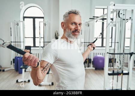 Sportsman with cable machine handles in his hands looking ahead Stock Photo