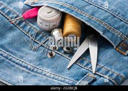 Sewing Tools In Pocket Of Blue Jeans Close Up. Stock Photo