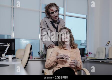 Two dead or zombie managers working in office environment Stock Photo