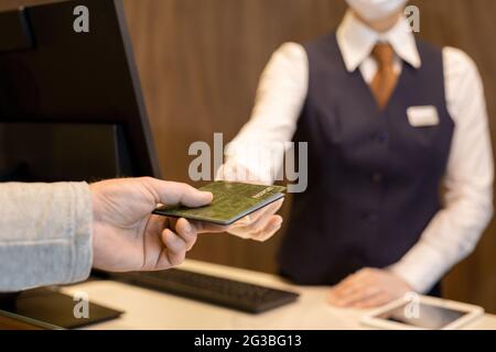 Hand of mature man taking back his passport after registration Stock Photo
