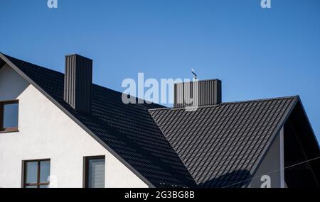 Grey corrugated metal profile roof installed on a modern house. The roof of corrugated sheet. Roofing of metal profile wavy shape. Modern roof made of Stock Photo