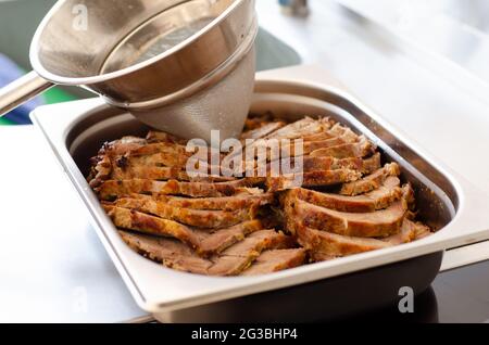 Kitchen funnel topping pork with creamy sauce Stock Photo