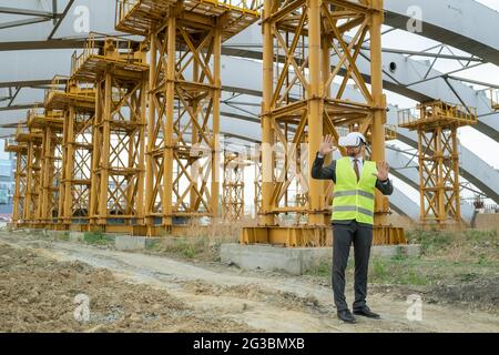 Young male builder in hardhat, formalwear and vr headset touching virtual screen Stock Photo