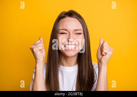 Photo portrait of cheerful hopeful girl with closed eyes isolated on vivid yellow colored background Stock Photo