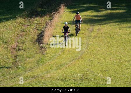 Two girls on mtb bikes. Mother and daughter riding on a trail. Stock Photo