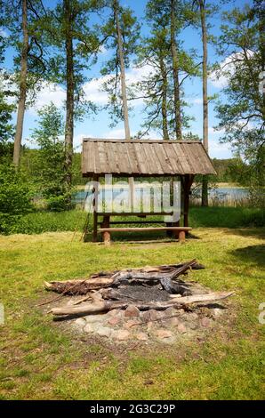 Bonfire and picnic area in a forest by a lake. Stock Photo
