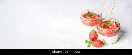 Banner with Panna cotta desserts in glass jars. Stock Photo