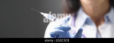 Doctors hand in rubber glove holding syringe with medicine closeup Stock Photo