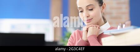 Young woman reading book and smiling in office Stock Photo