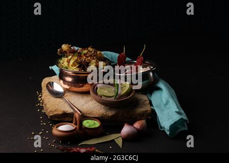 Spicy chicken dum biryani in traditional handi or clay pot. served with onion raita Stock Photo
