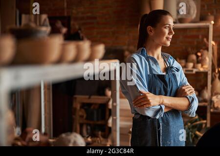 Thoughtful young Caucasian lady enjoy good working day in art modern studio Stock Photo
