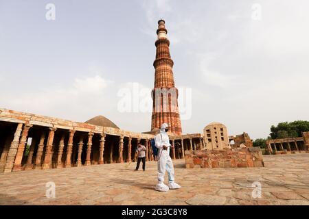 New Delhi, India. 15th June, 2021. A worker wearing a Personal Protective Equipment suite (PPE) chemically disinfects the premises of the Qutub Minar complex ahead of its reopening to the public after the lockdown in New Delhi. Indian Statistical Institute (ASI) Protected monuments and museums are scheduled to reopen from June 16th. Delhi has over 70 monuments under ASI, including Red Fort, Humayuns Tomb, Qutub Minar and Purana Qila. Credit: SOPA Images Limited/Alamy Live News Stock Photo