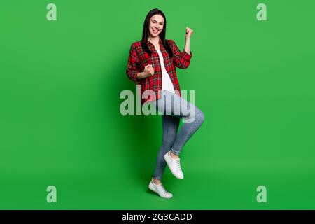 Full size profile photo of brunette hooray young lady hands fists wear shirt jeans isolated on green color background Stock Photo
